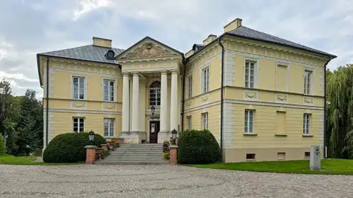 Pałac w Dobrzycy, elewacja frontowa w stylu klasycystycznym z portykiem kolumnowym.