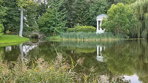 Klasycystyczna rotunda (Monopter) nad stawem w parku Pałacu w Dobrzycy, widoczny mostek.