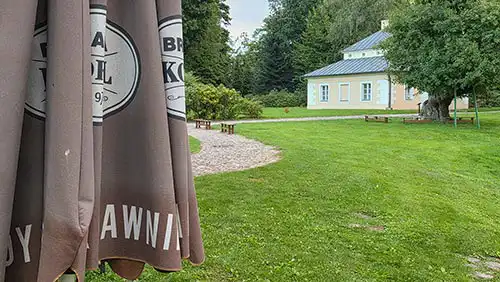 Teren rekreacyjny w parku pałacowym w Dobrzycy. Widok boczny pałacu na tle trawnika.