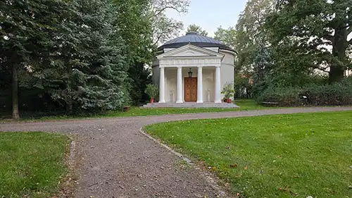 Panteon w Dobrzycy. Klasycystyczna budowla z portykiem kolumnowym i drewnianymi drzwiami.